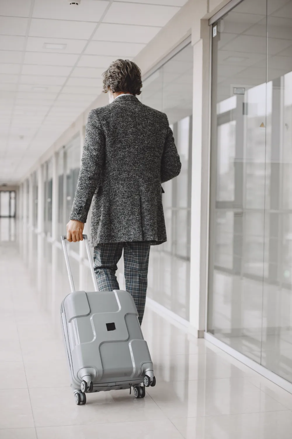Businessman pulling a suitcase through an airport corridor